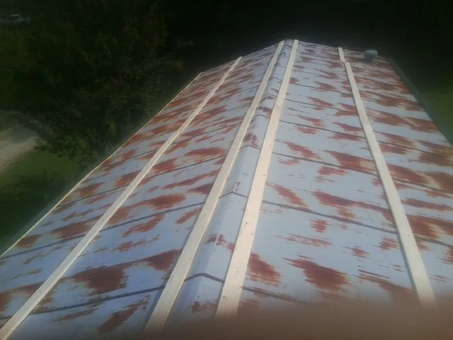 Rusted metal roof panels with new wood purlins before replacement — Storm Damage Roof Repair in Edinburg by Roofing Brothers